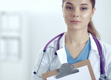 Kadın doktor hastanede dosyayla bekliyor.