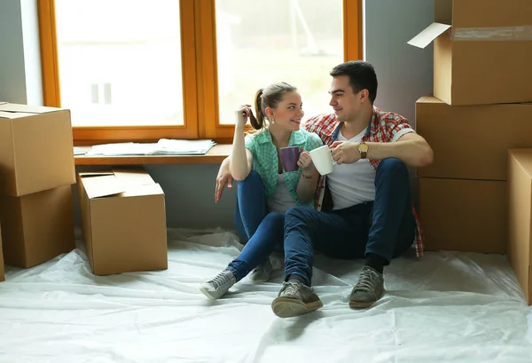 Par som flyttar i huset sitter på golvet — Stockfoto