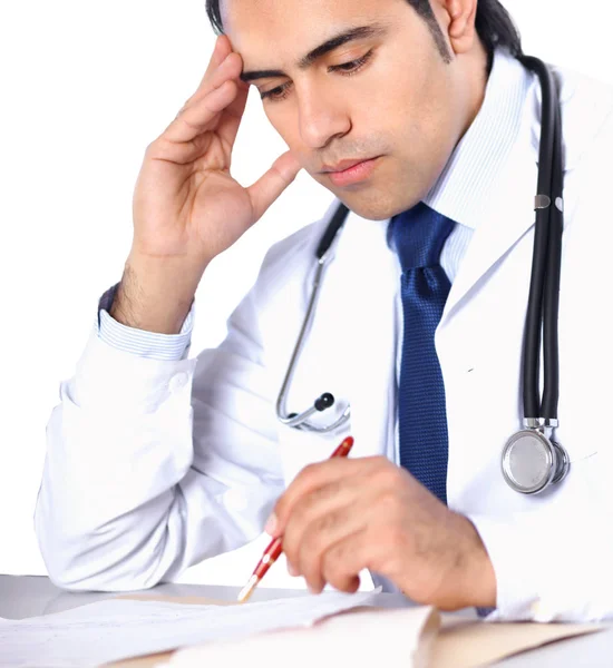 Male doctor sitting at the desk on white background — Stock Photo, Image