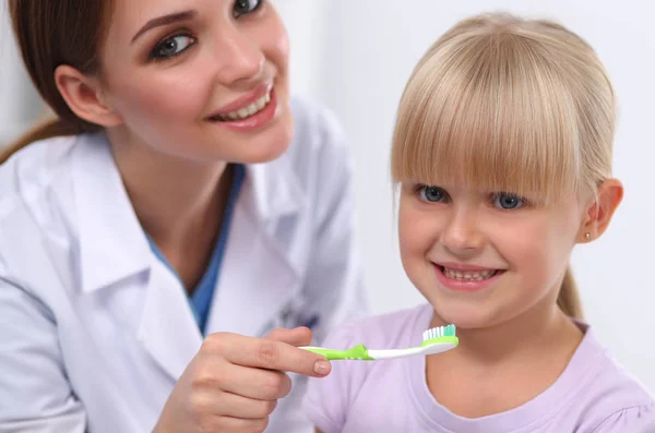 Tandläkare och liten flicka på tandläkarmottagningen. — Stockfoto