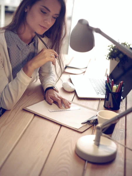 Joven mujer trabajando sentada en un escritorio —  Fotos de Stock