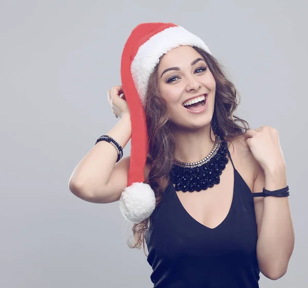 Attraktive lächelnde Frau mit Weihnachtsmannmütze. isoliert vor grauem Hintergrund. — Stockfoto
