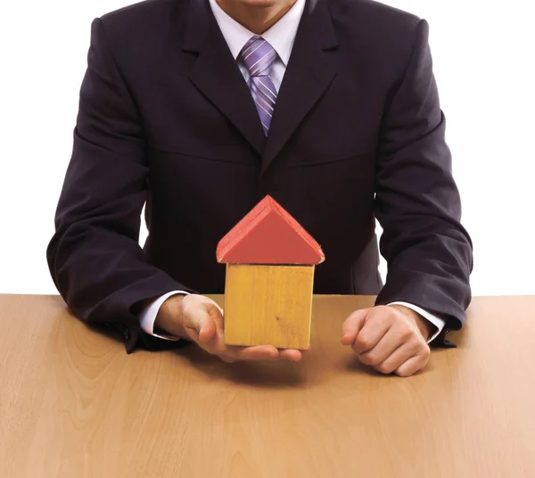 Businessman signs contract behind home architectural model — Stock Photo, Image