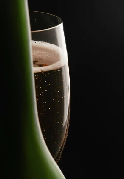 Glas Wein und Flasche auf schwarzem Hintergrund — Stockfoto