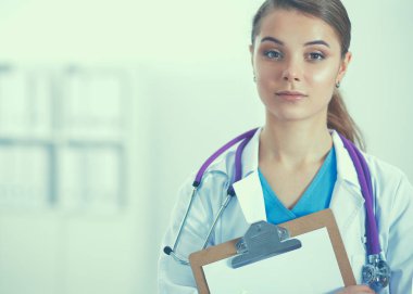 Kadın doktor hastanede dosyayla bekliyor.