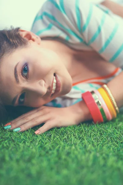 Hermosa mujer joven acostada en la hierba verde — Foto de Stock