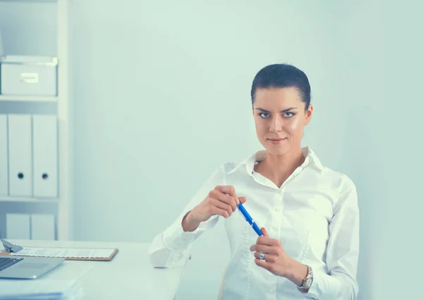 Jeune femme assise à la table de bureau avec ordinateur portable — Photo