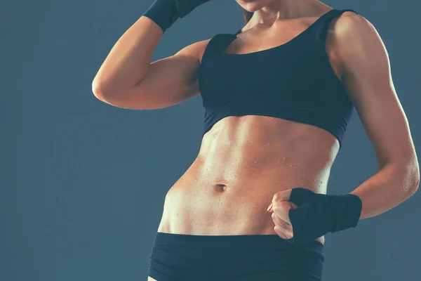 Musculosa joven de pie sobre fondo gris — Foto de Stock