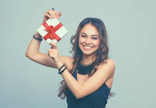 Mujer joven sonrisa feliz celebrar caja de regalo en las manos, aislado sobre fondo gris — Foto de Stock