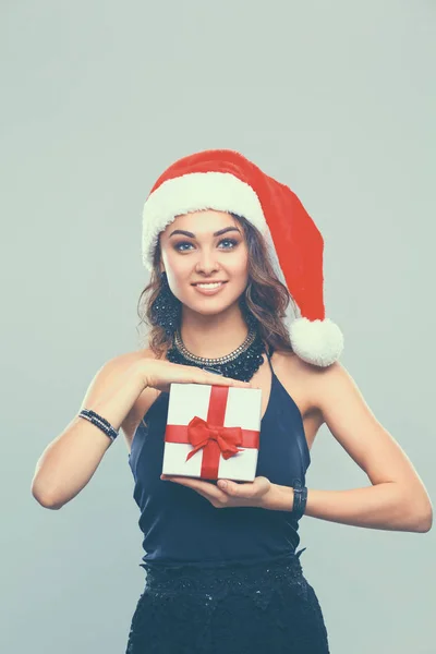 Junge glückliche Frau mit Weihnachtsmütze hält Weihnachtsgeschenk in der Hand — Stockfoto