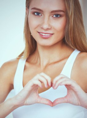 Güzel kadın kalp şekli elinde, gösterilen yatak oturma