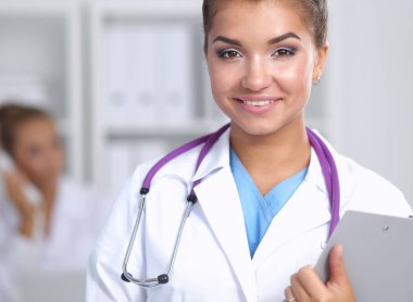 Hastanede üniformalı, gülümseyen bir kadın doktor.