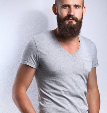 Ayakta, gri arka plan üzerinde izole yakışıklı adam portresi