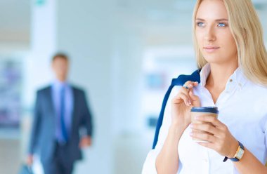 Yound kadın ayakta ofisindeki kahve içmek