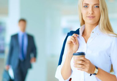 Yound kadın ayakta ofisindeki kahve içmek