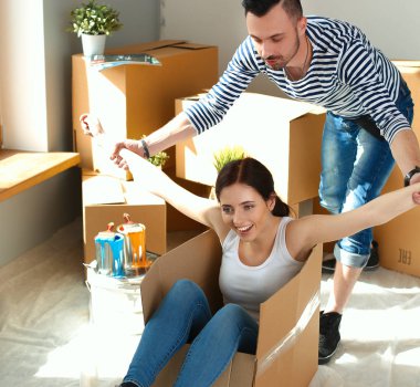 Mutlu çift eğleniyor ve yeni evlerinde karton kutularda geziyorlar.