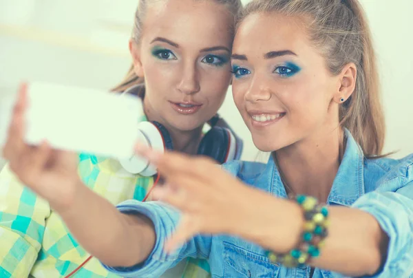 Две девушки фотографируют дома по телефону — стоковое фото