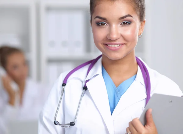 Uśmiechnięta lekarka w mundurze stojąca w szpitalu — Zdjęcie stockowe