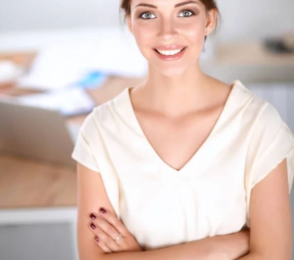 Attraktive Geschäftsfrau steht an Wand im Büro — Stockfoto