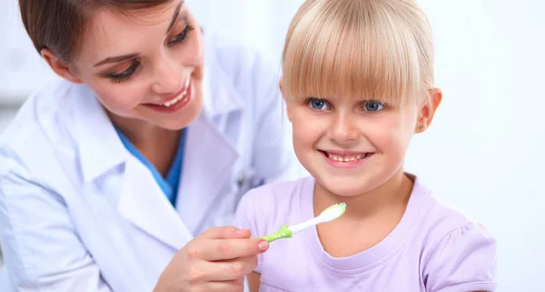 Tandarts en klein meisje in het tandartspraktijk — Stockfoto