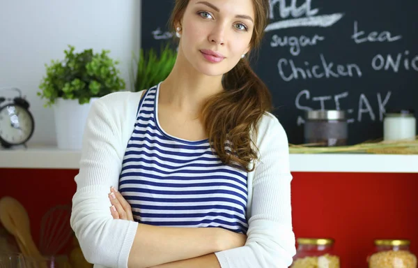 Giovane donna in piedi vicino alla scrivania in cucina — Foto Stock