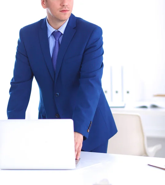 Homem de negócios ou gerente de pé contra sua mesa no escritório — Fotografia de Stock