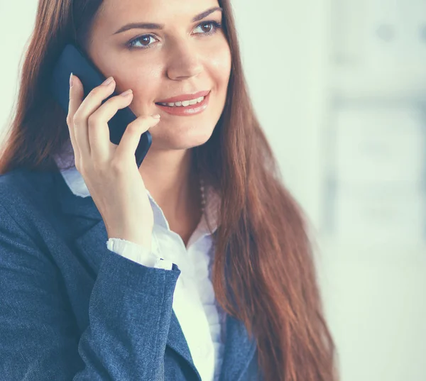 Uśmiechnięta bizneswoman rozmawiająca przez telefon w biurze — Zdjęcie stockowe