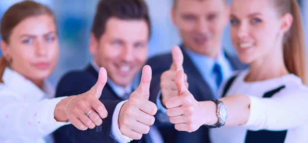 Happy business team showing thumbs up in office — Stock Photo, Image