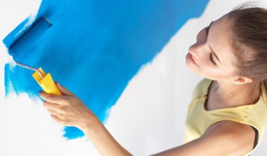 Duvar Boyama yaparken, merdiven üzerinde duran mutlu güzel genç kadın