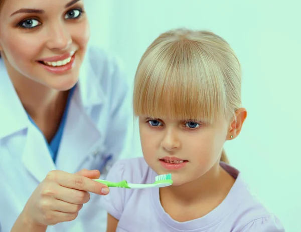 Tandläkare och liten flicka på tandläkarmottagningen — Stockfoto