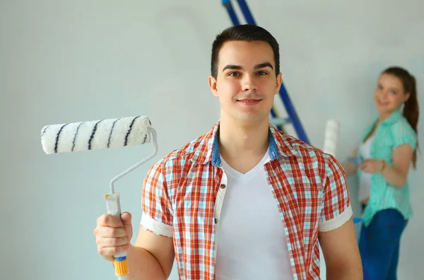 Portret van gelukkig lachend jong koppel schilderij interieur wand nieuw huis — Stockfoto