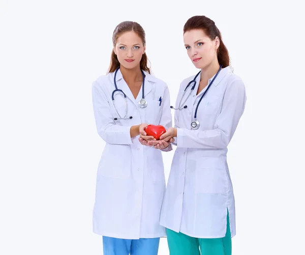 Dos doctora sosteniendo un corazón rojo, aislada sobre fondo blanco —  Fotos de Stock