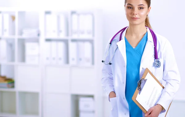 Woman doctor standing with folder at hospital — Stock Photo, Image