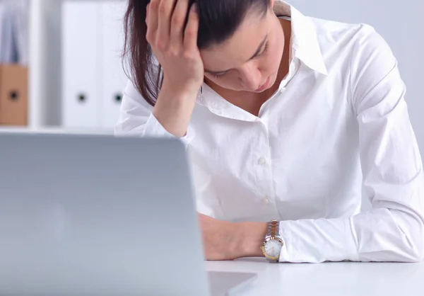 Stressed businesswoman sitting at desk in the office Royalty Free Stock Photos