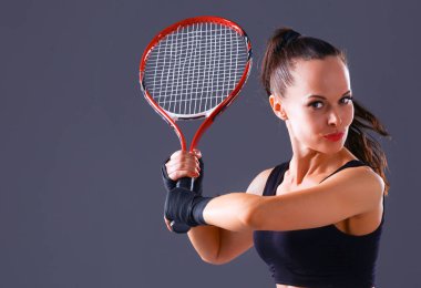 Gri arka plan üzerinde Tenis oynayan kadın