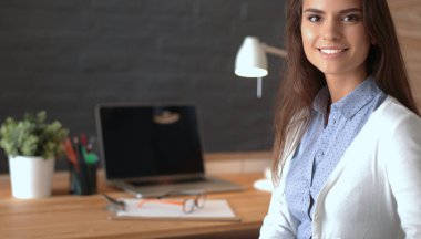 Masada oturan genç bir kadın.