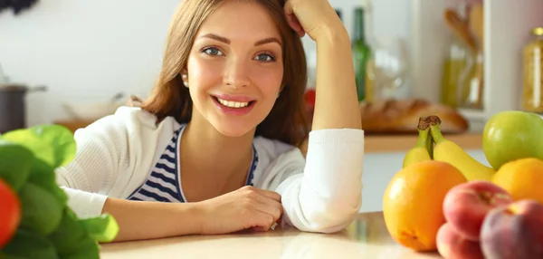 Young woman standing near desk in the kitchen — Stock Photo, Image