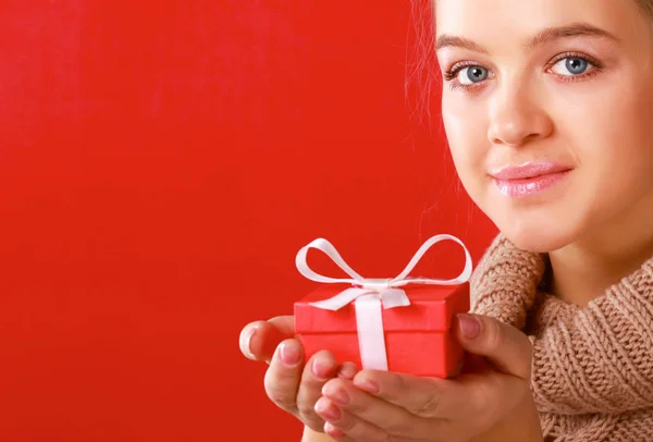 Young woman is standing while holding a bag of gifts over her shoulder — Stock Photo, Image