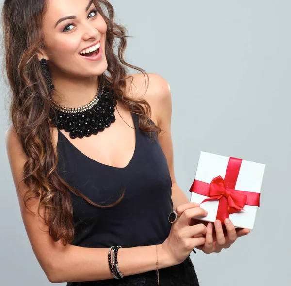 Mujer joven sonrisa feliz celebrar caja de regalo en las manos, aislado sobre fondo gris — Foto de Stock