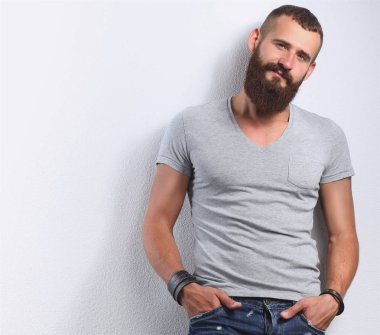 Ayakta, gri arka plan üzerinde izole yakışıklı adam portresi