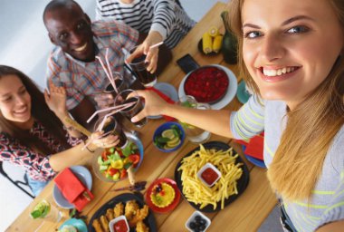Öğle yemeği sırasında selfie çeken bir grup insan.