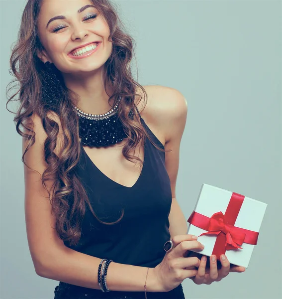 Młoda kobieta szczęśliwy uśmiech trzymać pudełko w ręce, na białym tle nad szarym tle — Zdjęcie stockowe