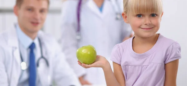 Concepto de niño y medicina - doctora dando una manzana a una niña sonriente —  Fotos de Stock