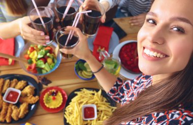 Öğle yemeği sırasında selfie çeken bir grup insan.