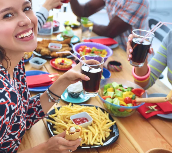 Gruppe von Menschen beim gemeinsamen Abendessen am Holztisch — Stockfoto