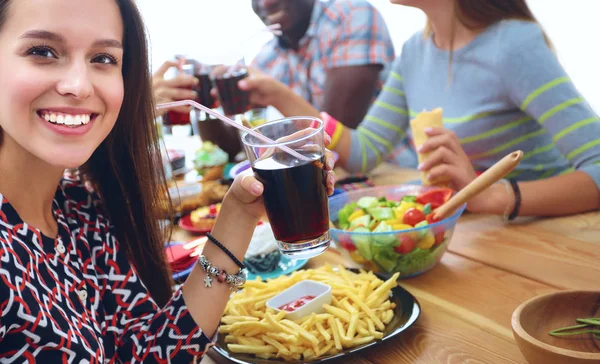 Grupo de pessoas jantando juntas enquanto sentadas à mesa de madeira — Fotografia de Stock