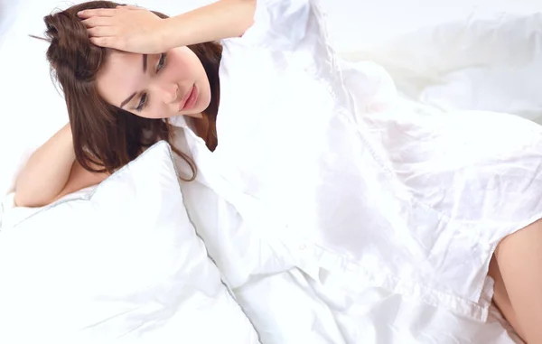 Portrait de belle femme, elle assise sur un lit blanc — Photo