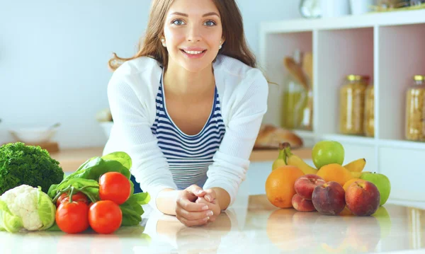 Jonge vrouw zit in de buurt van bureau in de keuken — Stockfoto