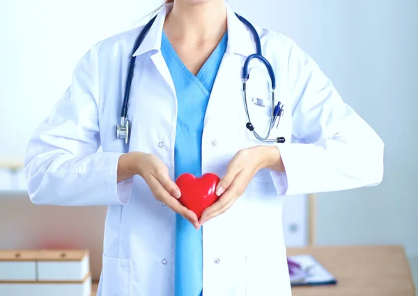 Kvinna läkare med stetoskop som håller hjärtat — Stockfoto