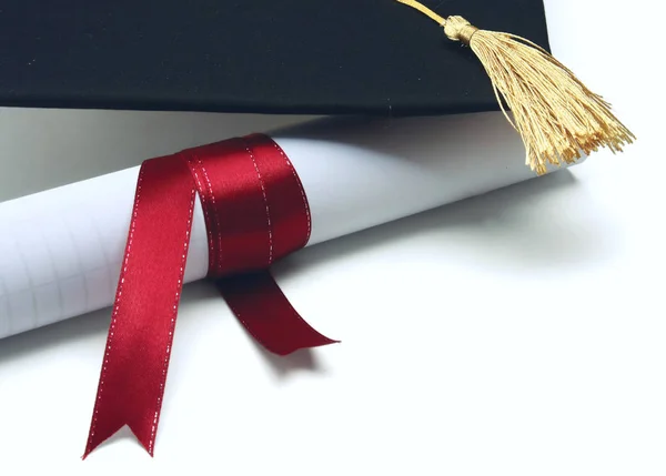 Egy egyetemi diploma, elszigetelt fehér piros szalaggal — Stock Fotó